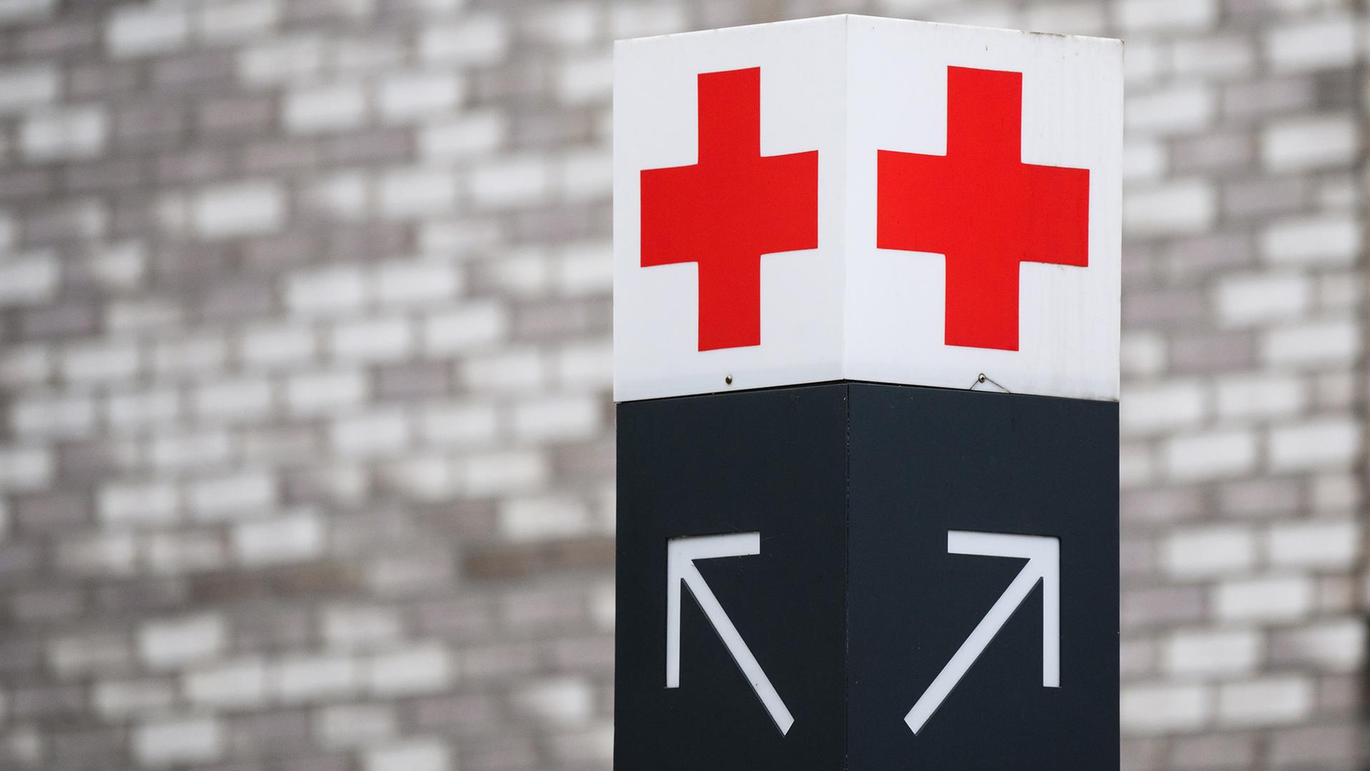 Ein Schild mit einem roten Kreuz weist den Weg zur Notaufnahme. | dpa