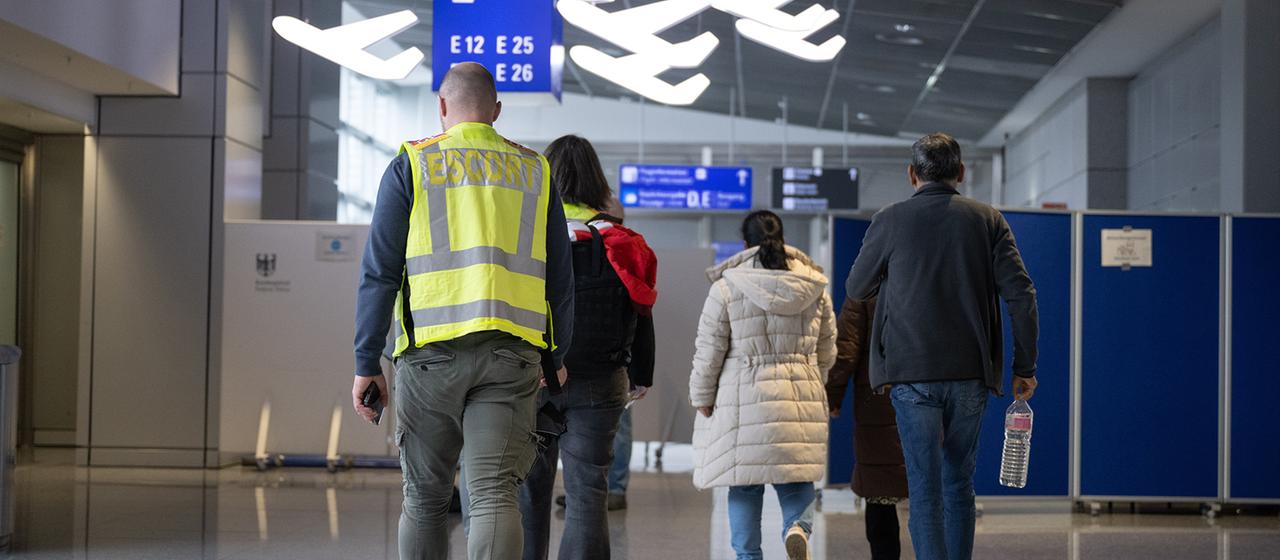 Eine Familie wird von Beamten der Bundespolizei zu einem Abschiebeflug nach Pakistan begleitet.