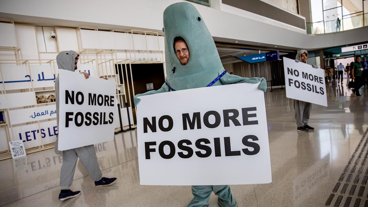 Verkleidete Klimaaktivisten fordern auf der Klimakonferenz in Dubai den Ausstieg aus fossilen Energien. | EPA