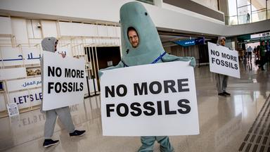 Verkleidete Klimaaktivisten fordern auf der Klimakonferenz in Dubai den Ausstieg aus fossilen Energien.
