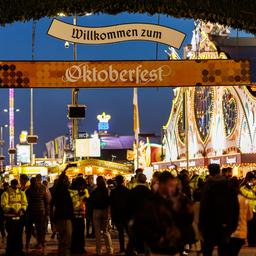 Sicherheitsbeamte stehen am Rande von Fahrgeschäften auf dem Oktoberfest.