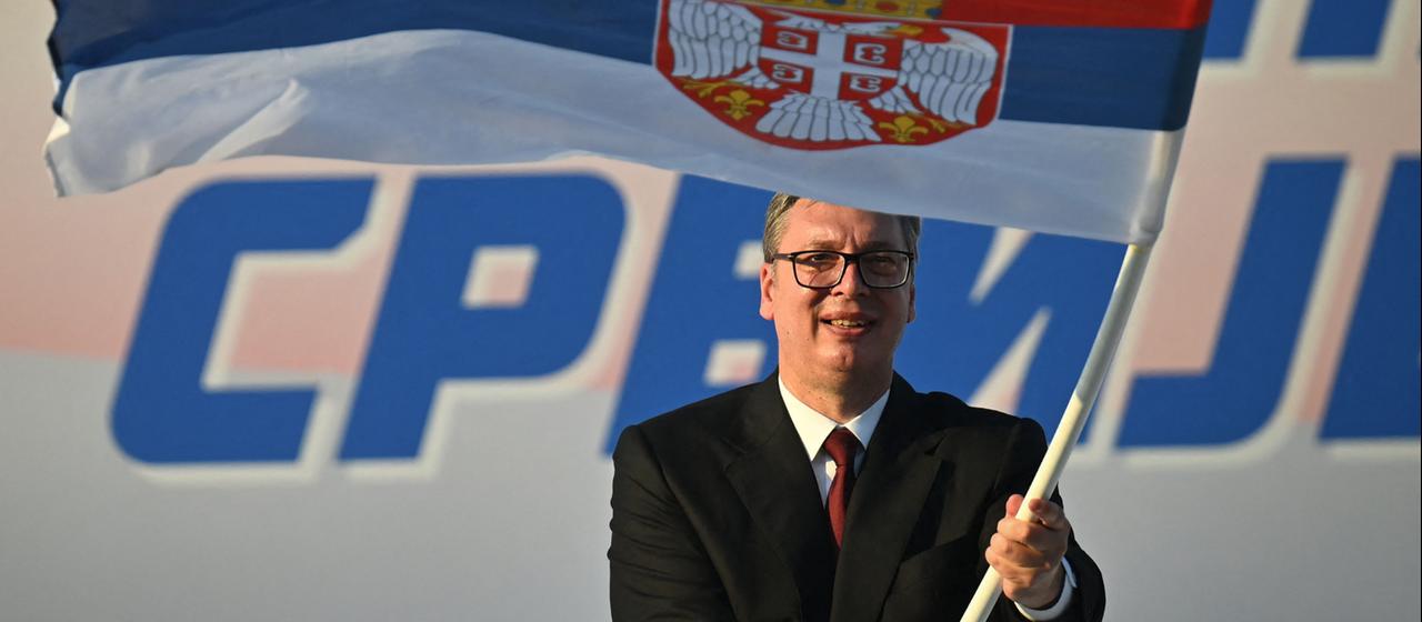 Aleksandar Vucic schwenkt eine serbische Flagge.