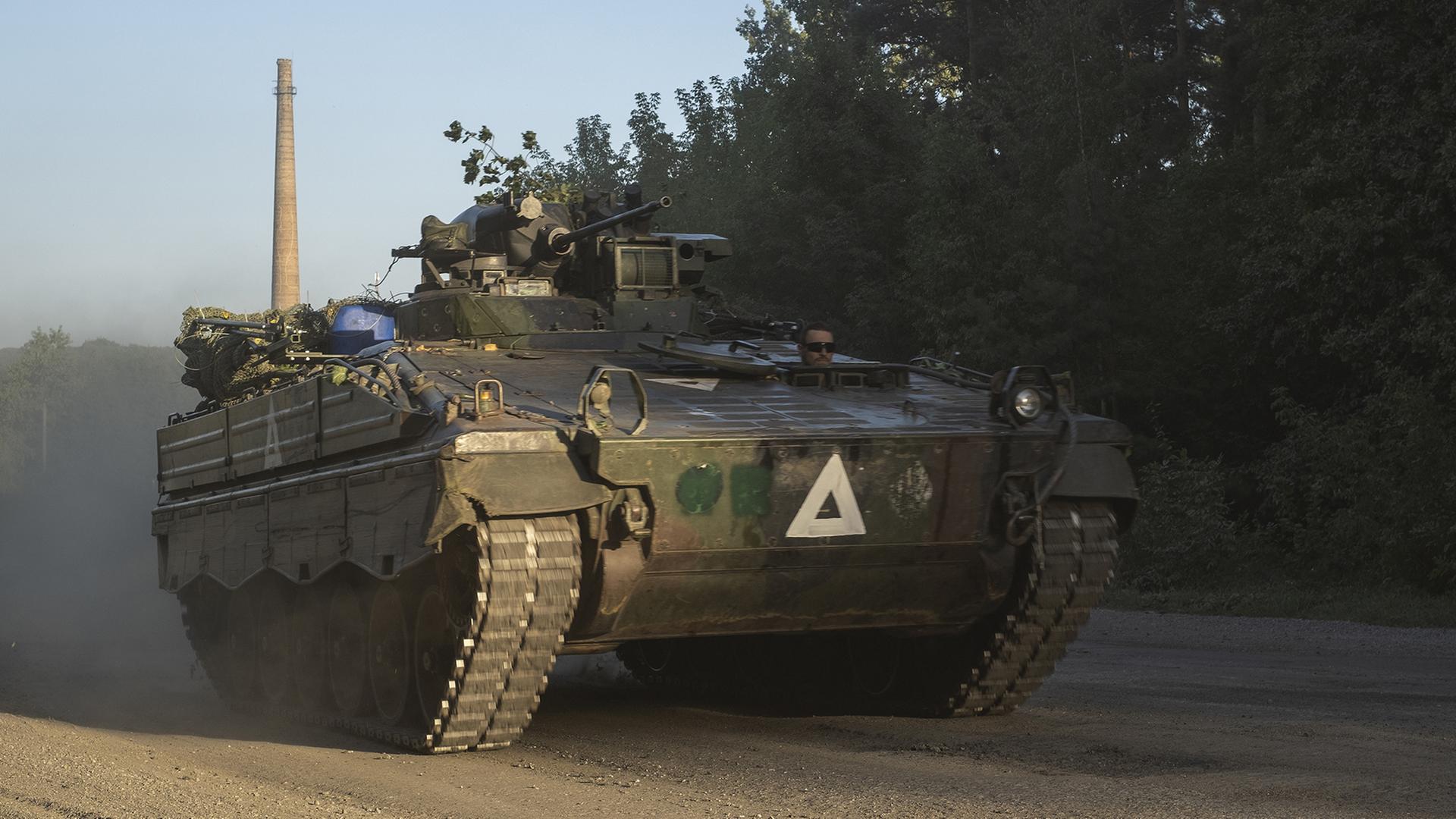 Ukrainische Soldaten fahren mit einem gepanzerten Mannschaftstransportwagen auf einer Straße in der Region Sumy. | EPA