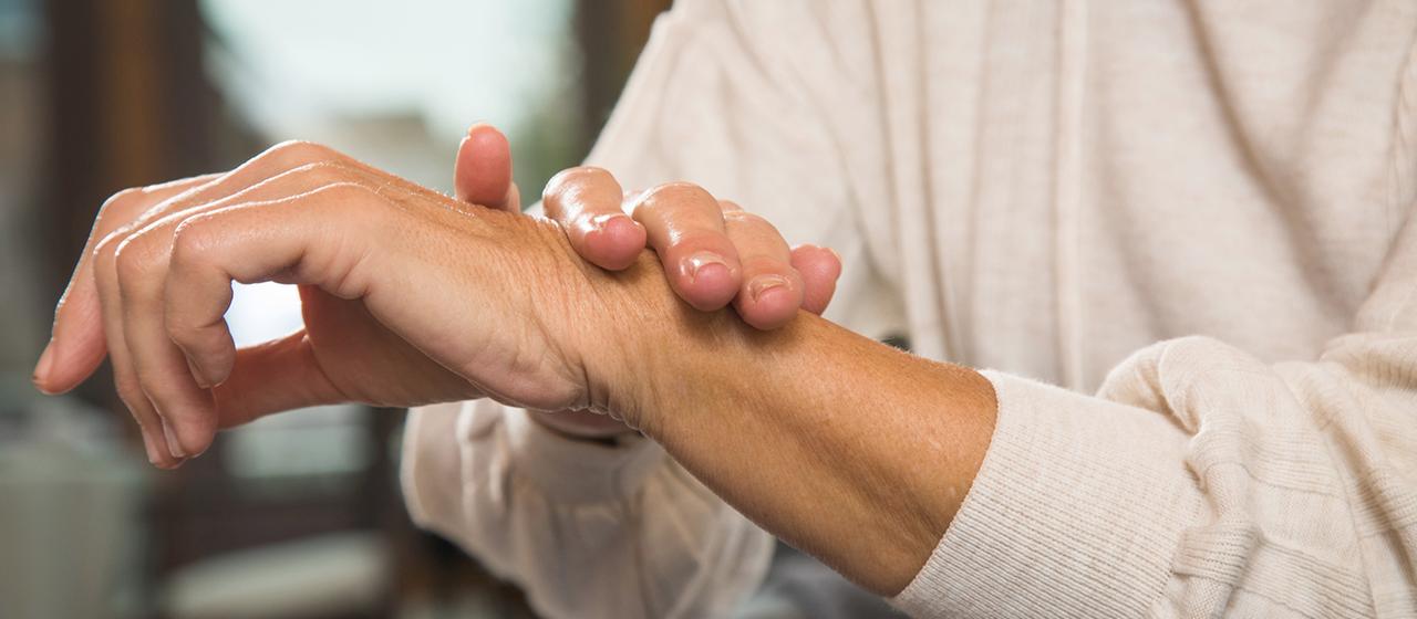 Eine ältere Frau fasst sich ans Handgelenk. | picture alliance / dpa-tmn Eine ältere Frau fasst sich ans Handgelenk.