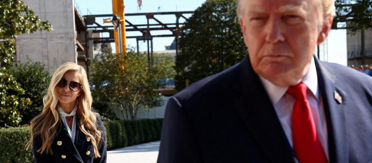 Katie Zacharia steht hinter Donald Trump, als er das Weiße Haus verlässt