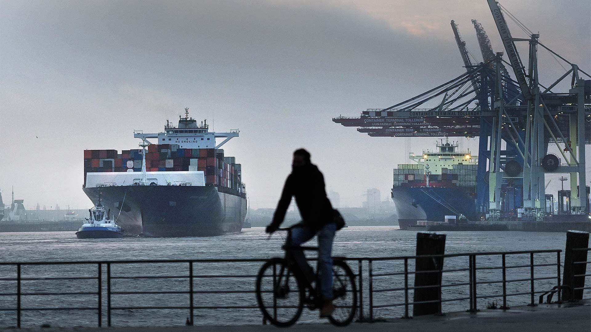 Ein Containerschiff wird an einen Terminal im Hamburger Hafen geschleppt. | picture alliance/dpa