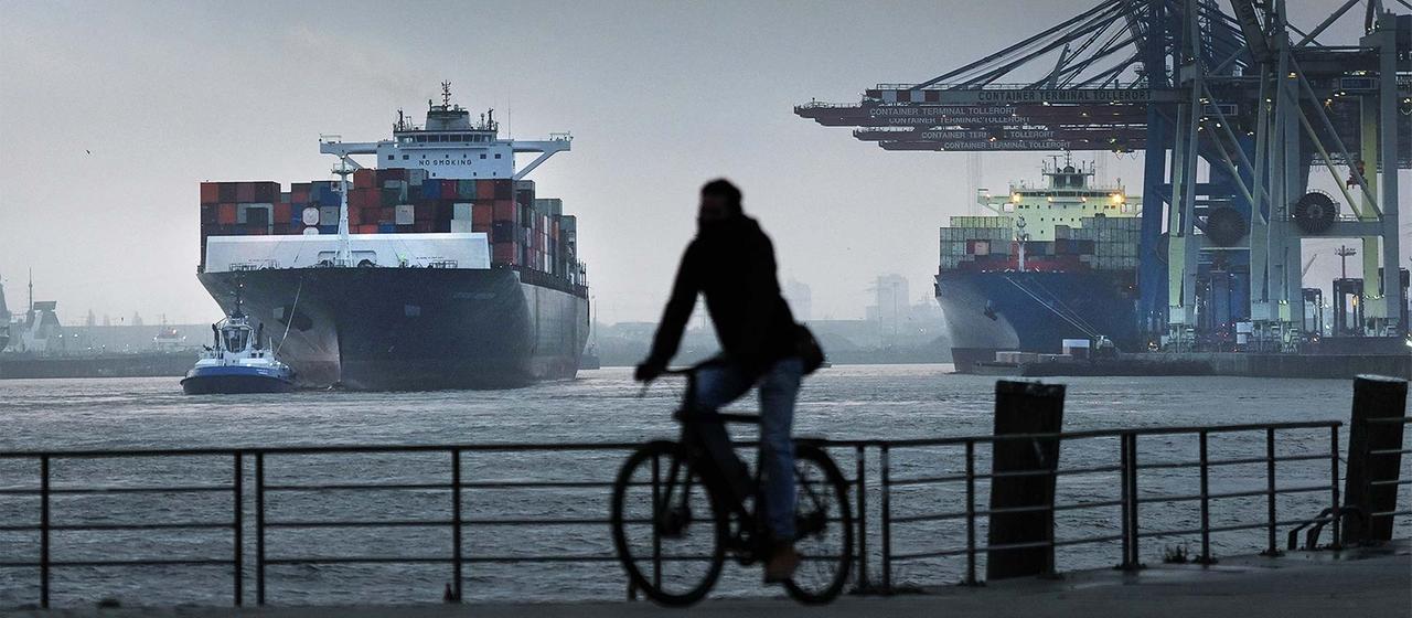 Ein Containerschiff wird an einen Terminal im Hamburger Hafen geschleppt.