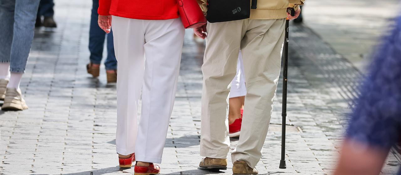 Ein Seniorenpaar geht durch die Innenstadt.