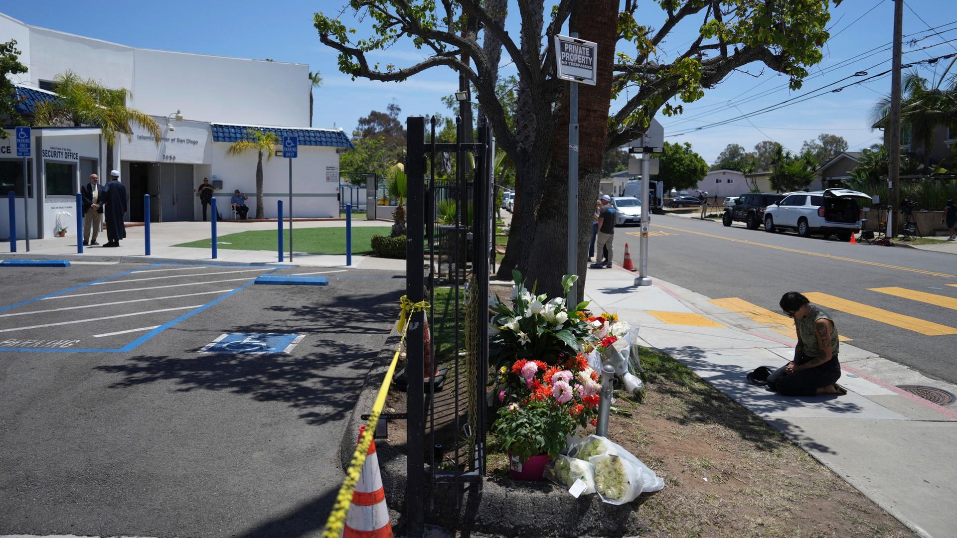 Eine Frau betet neben Blumen, die vor dem islamischen Zentrum in San Diego abgelegt wurden | AP Photo/Jae C. Hong