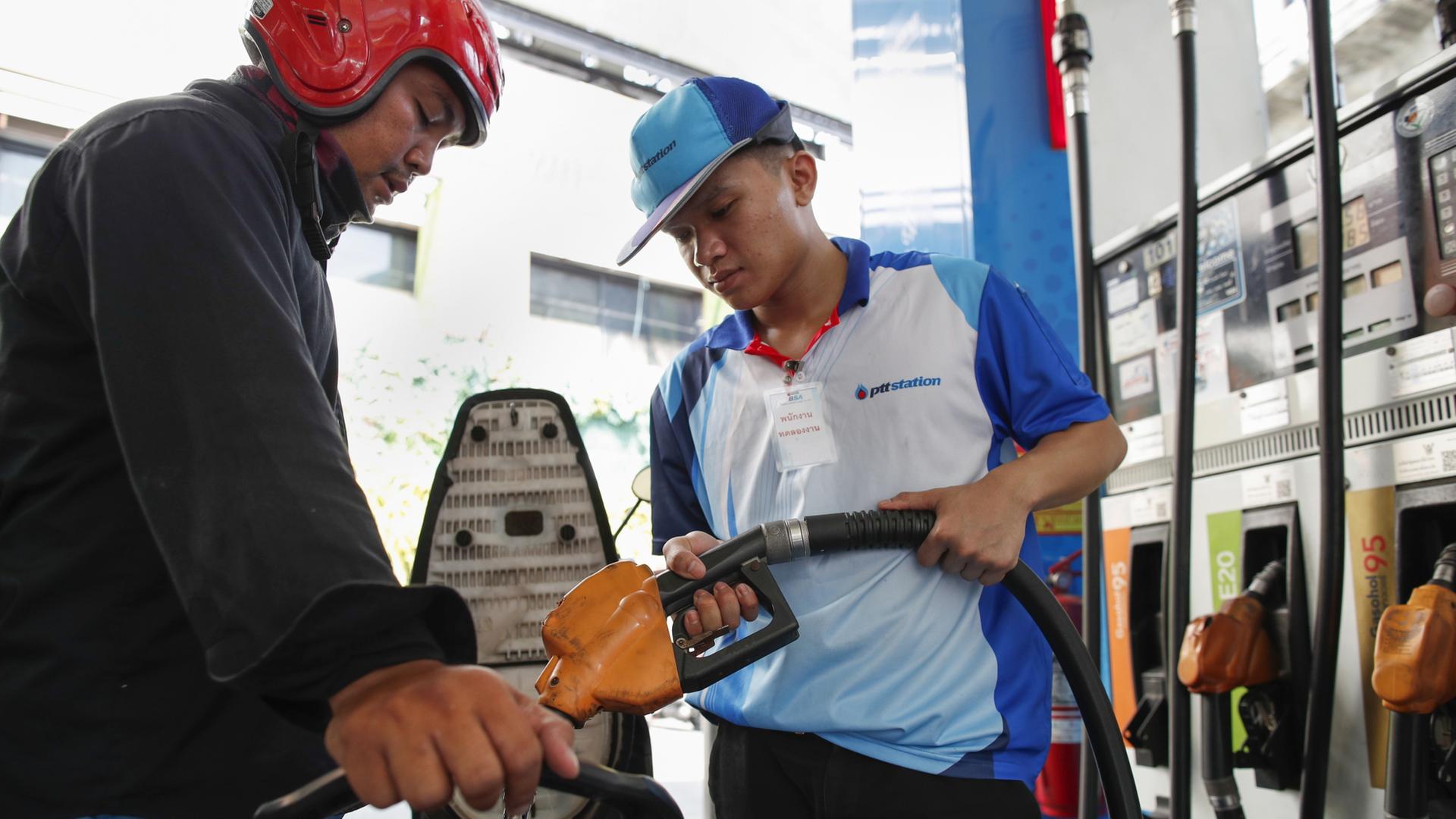 Ein Tankwart in Thailand betankt ein Moped. | EPA