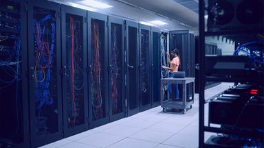 Technikerin arbeitet in einem Serverraum.
