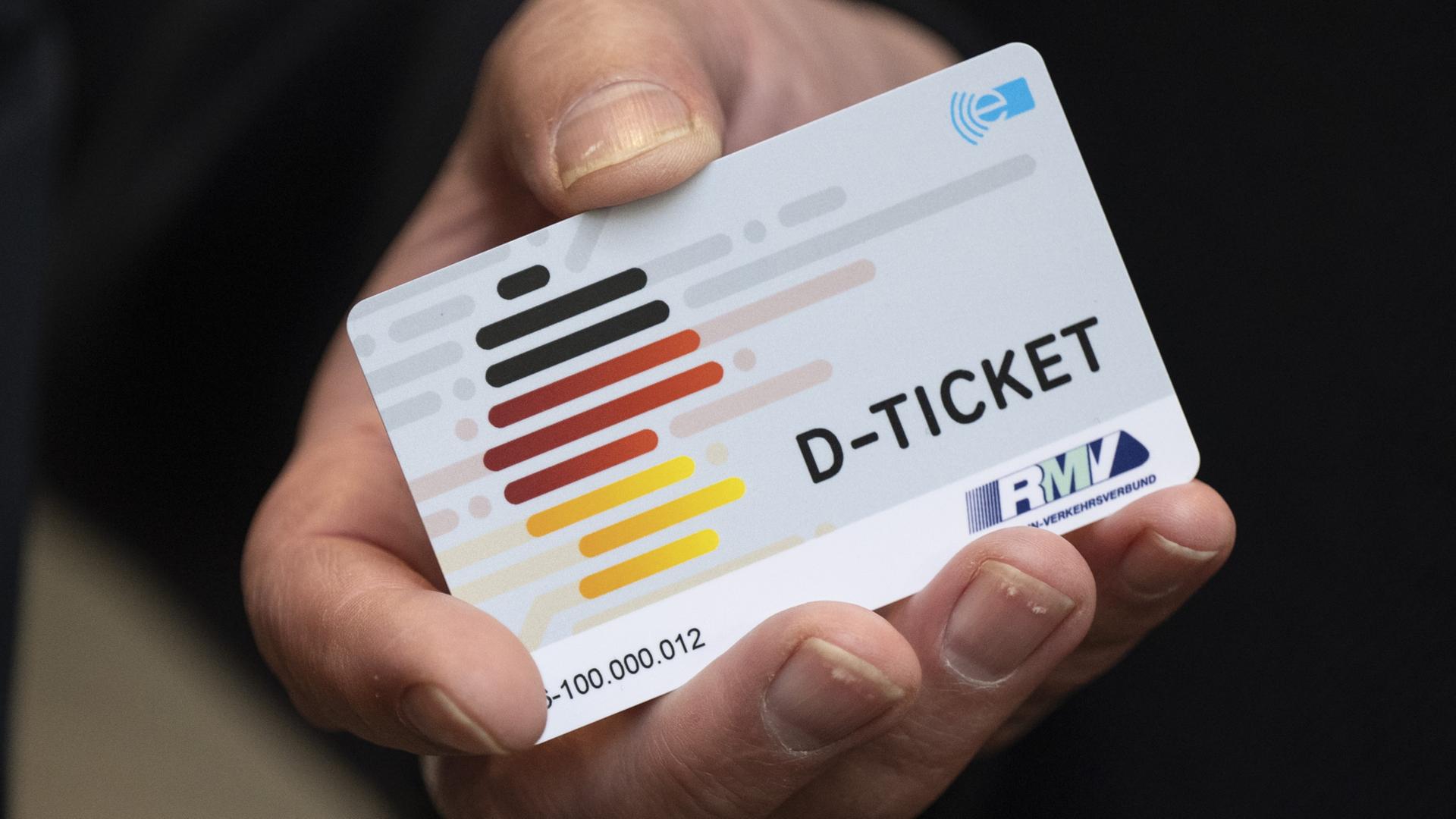 Eine Hand hält ein Deutschlandticket. | dpa