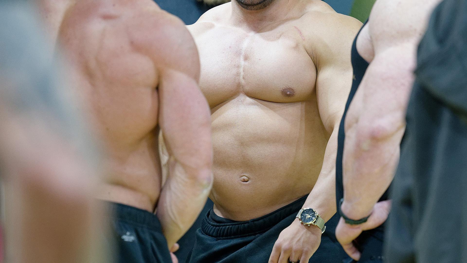 Eine Gruppe Bodybuilder mit nackten Oberkörpern. | picture alliance/dpa