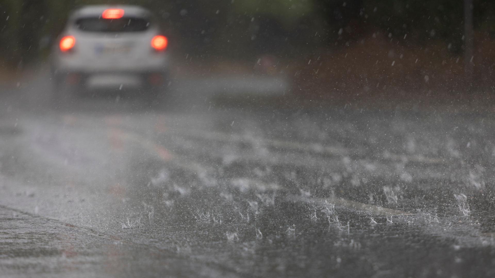 Wasser steht nach einem Regenguss durch ein Gewitter auf einer Straße. (Archivbild: 22.06.2023) | Tim Würz/dpa