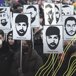 Mit Plakaten und Bildern der Ermordeten erinnern Teilnehmer einer Gedenkveranstaltung auf dem Marktplatz von Hanau an die Opfer der rassistisch motivierten Anschläge von Hanau im Jahr 2020.