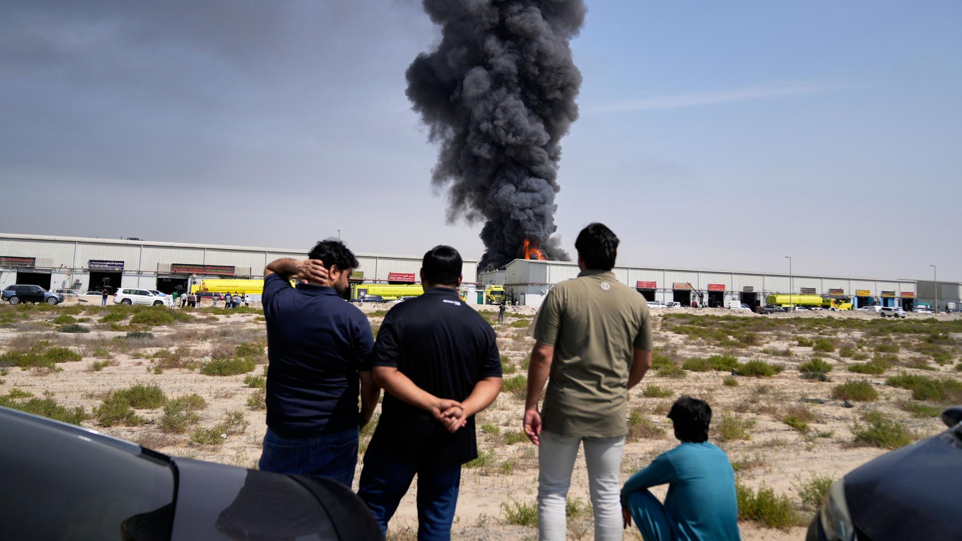 Anwohner beobachten, wie Flammen und eine schwarze Rauchwolke aus einem Lagerhaus im Industriegebiet von Sharjah City in den Vereinigten Arabischen Emiraten aufsteigen,  | Altaf Qadri/AP/dpa