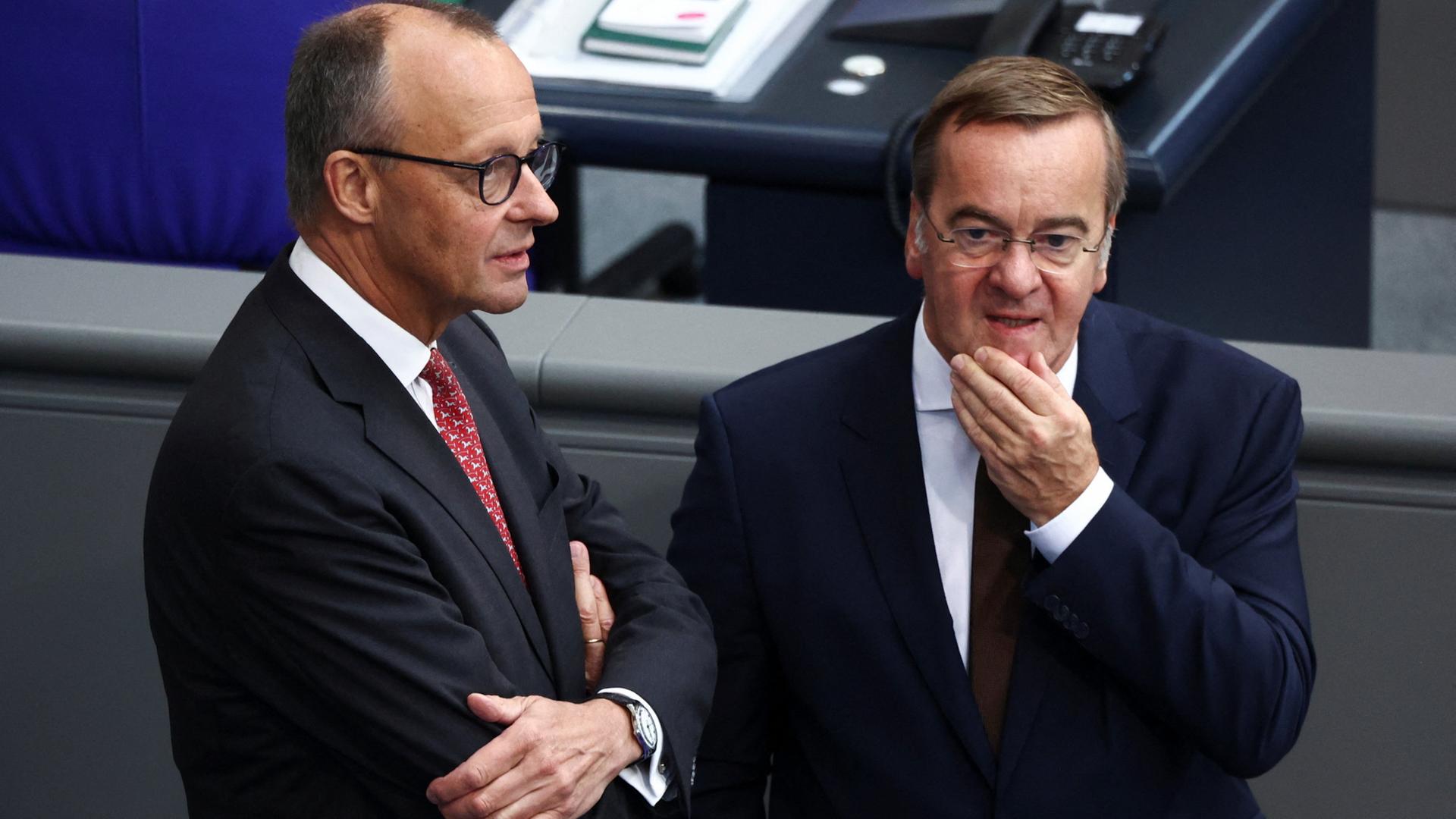 Friedrich Merz und Boris Pistorius stehen nebeneinander im Bundestag. | REUTERS