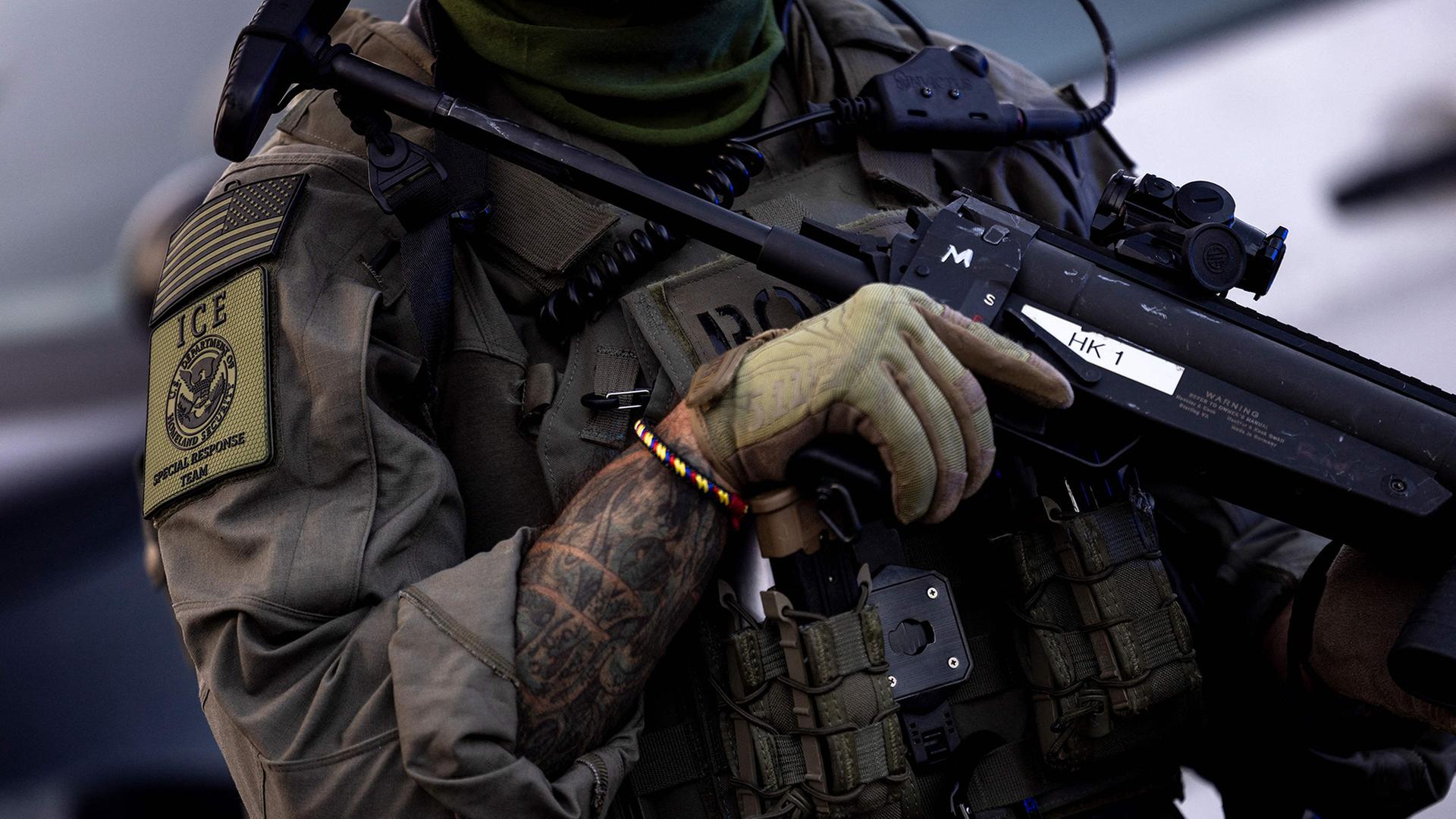 Ein Beamter der US-Einwanderungsbehörde ICE mit Schultergranatwerfer. | AFP