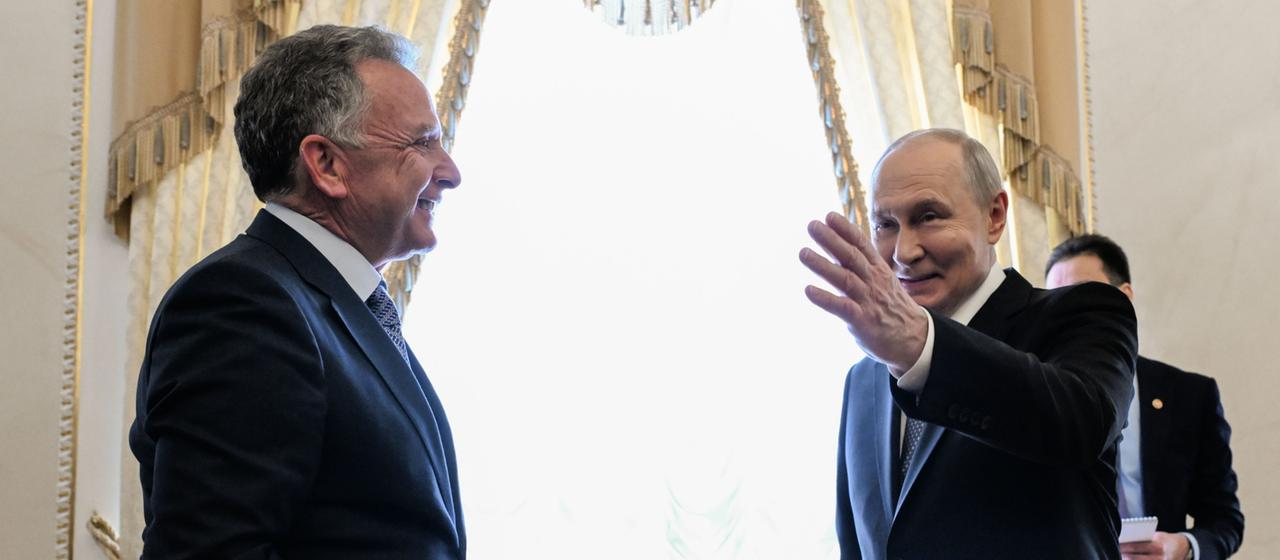 Russlands Präsident Wladimir Putin mit ausgestreckter Hand, neben ihm der US-Sondergesandte Steve Witkoff.