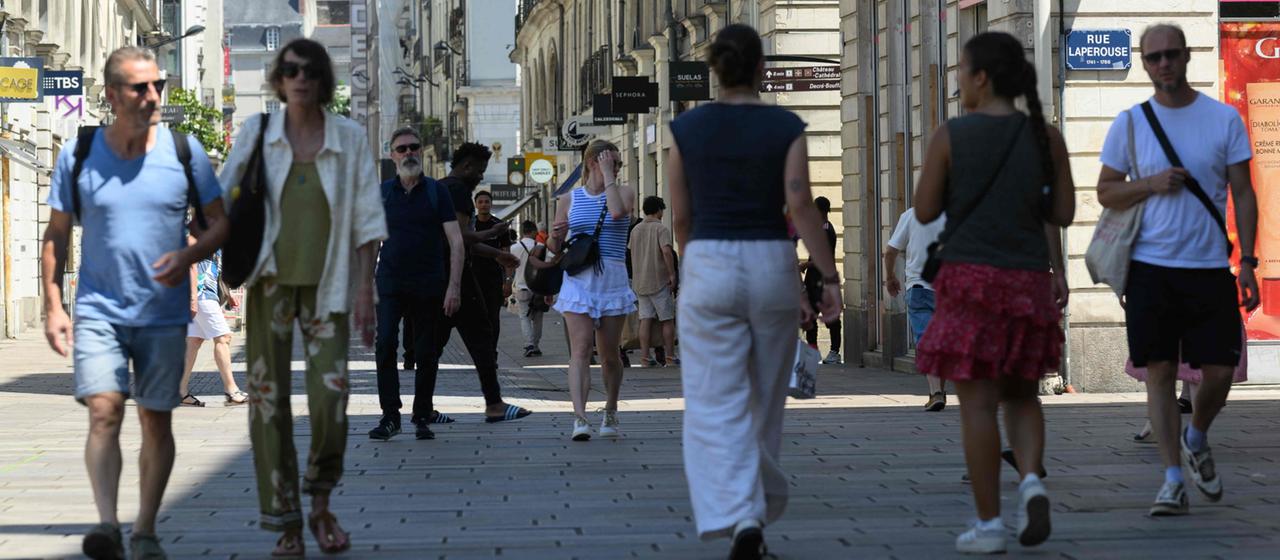 Menschen laufen durch die Innenstadt von Nantes, Frankreich.