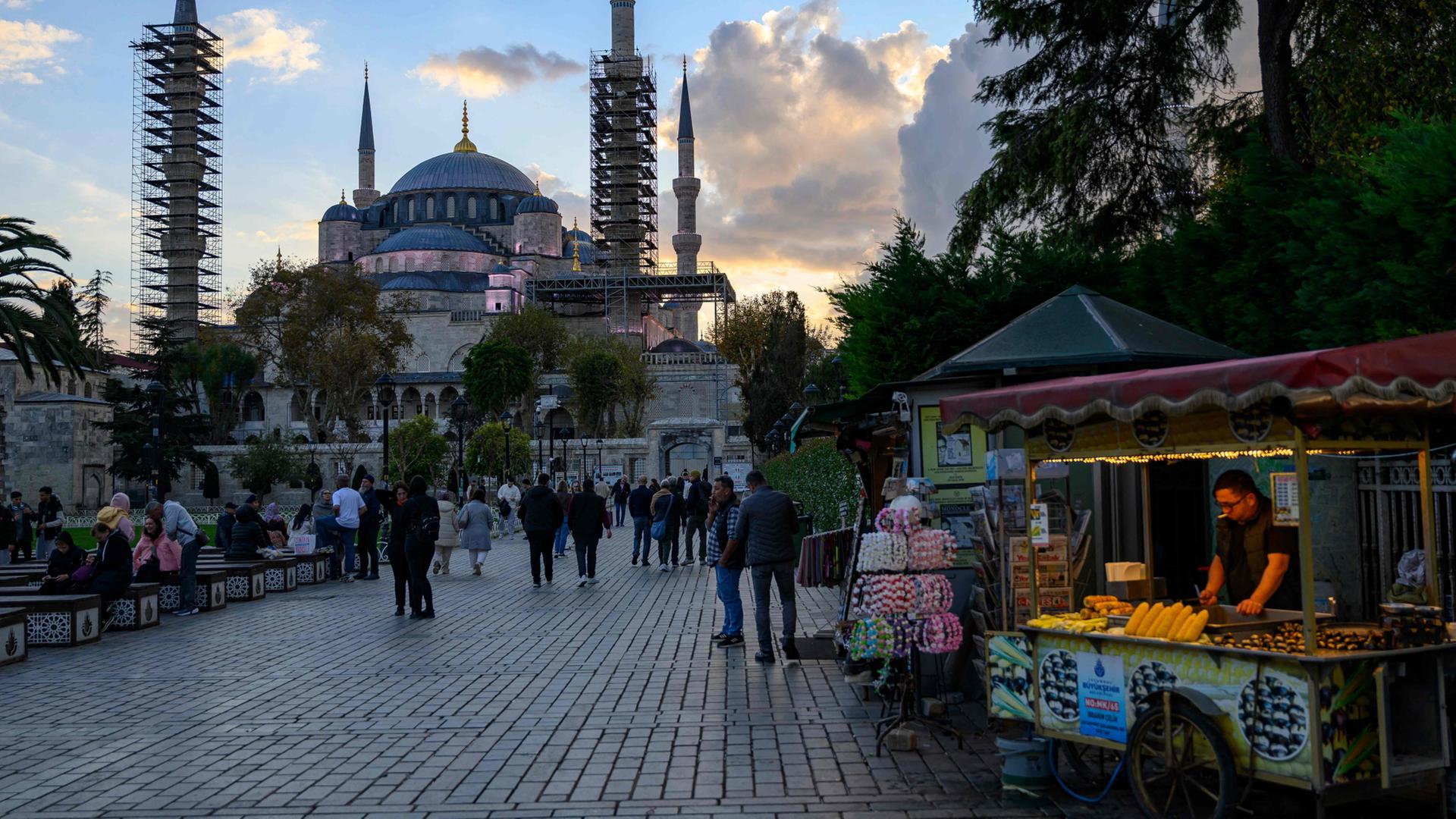 Menschen laufen einem Gehweg vor einer Moschee in Istanbul | AFP