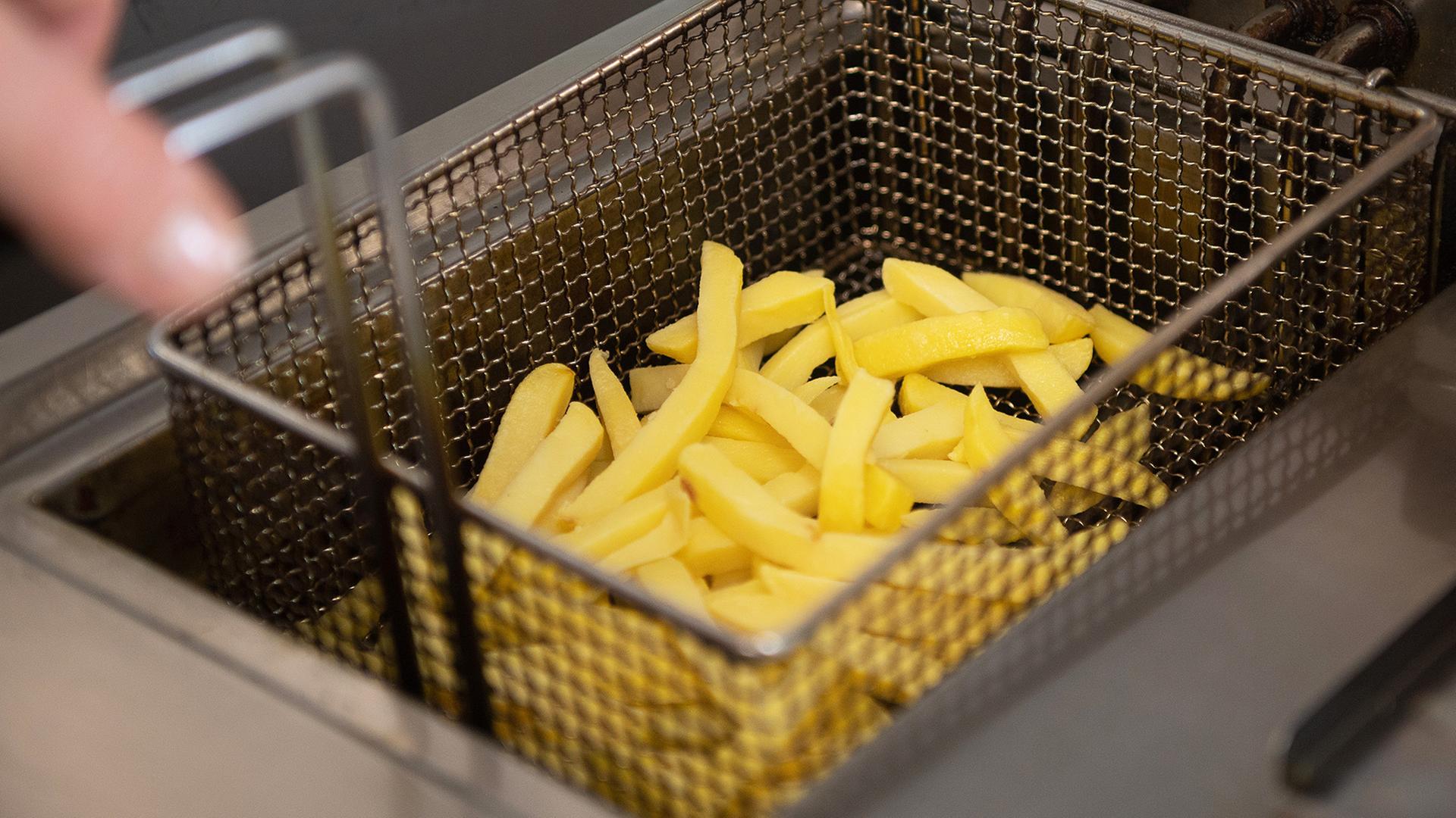 Pommes-Frites befinden sich in einer Gastronomie-Fritteuse. | dpa