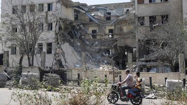 Menschen fahren an dem Gebäude des syrischen Verteidigungsministeriums in Damaskus vorbei.
