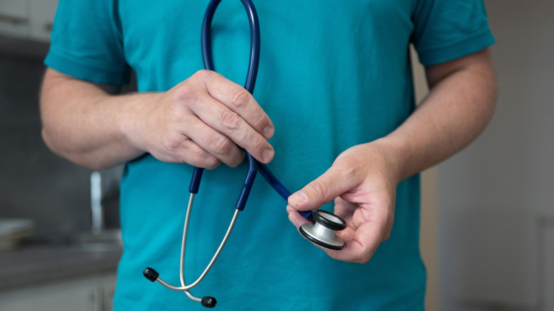 Ein Hausarzt steht in seiner Hausarztpraxis und h�lt ein Stethoskop. | dpa