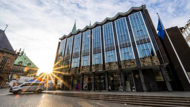 Die Sonne geht hinter der Bremischen Bürgerschaft auf.