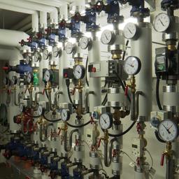 In einem Kellerraum des Niebüller Rathauses laufen Heizungsrohre, an denen Messgeräte installiert sind.