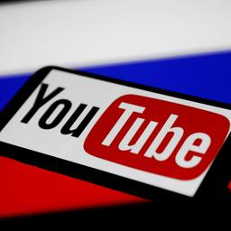 Ein Smartphone-Bildschirm mit dem Youtube-Logo vor der russischen Flagge.