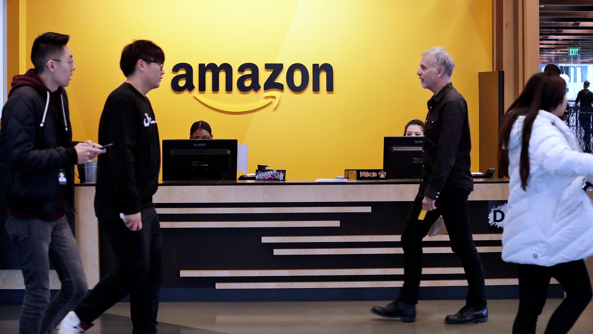 Mitarbeiter gehen durch eine Lobby der Amazon-Zentrale in Seattle. | dpa
