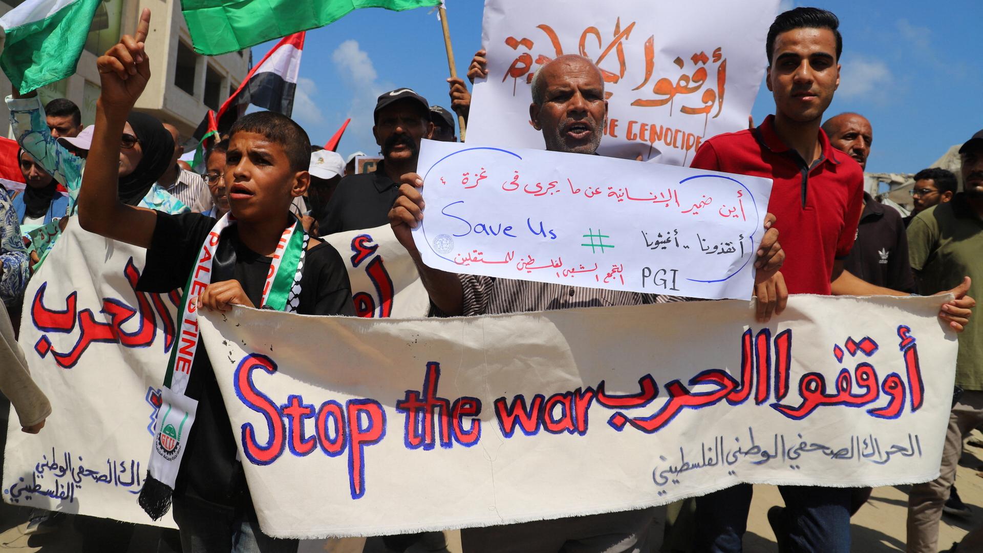 Protestierende halten Banner und Plakate in Gaza-Stadt. | REUTERS