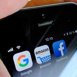 Logos für Apps der US-Internetkonzerne Google (l-r), Amazon und Facebook sind auf dem Display eines iPhone zu sehen.