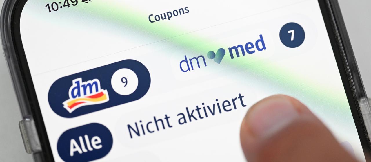 Die Logos von dm und der Online-Apotheke dm-med auf einem Smartphone