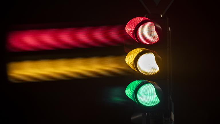 Eine Ampel zeigt die Lichter in grün, gelb und rot.