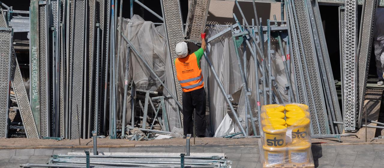 Gerüstbauer bauen ein Gerüst an einem Neubau mit Eigentumswohnungen in Köln, Nordrhein-Westfalen ab.