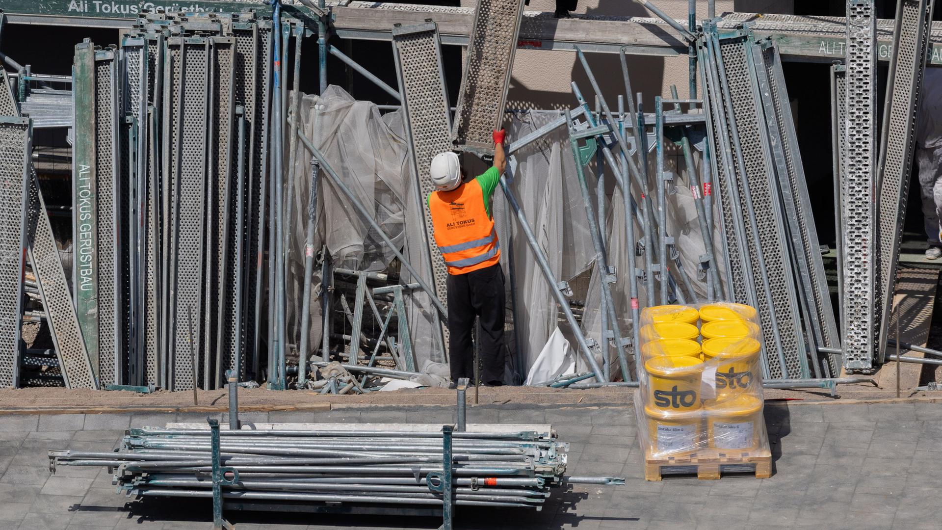 Gerüstbauer bauen ein Gerüst an einem Neubau mit Eigentumswohnungen in Köln, Nordrhein-Westfalen ab. | A3508 Rolf Vennenbernd/dpa