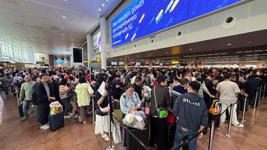 Fluggäste stehen in langen Warteschlangen auf dem Flughafen in Brüssel.