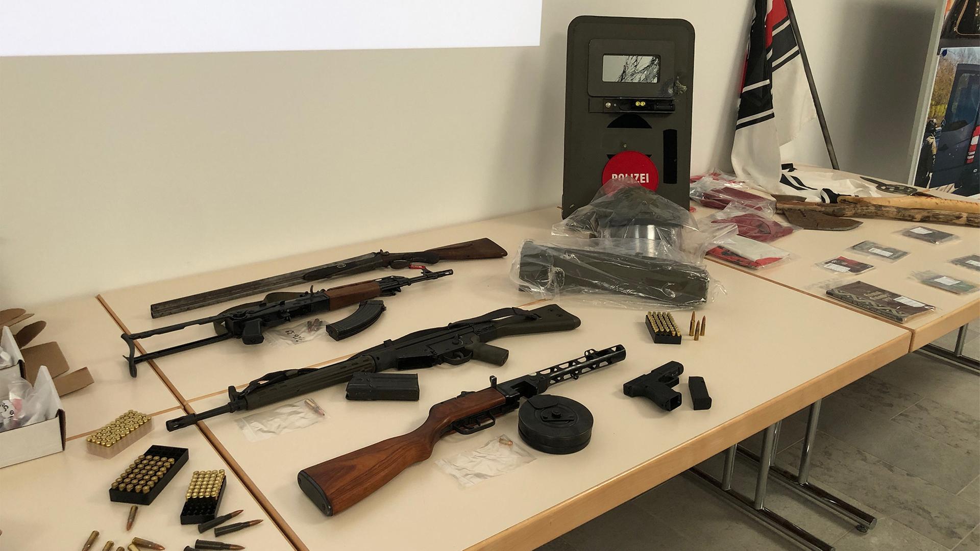 Auf einem Tisch liegen verschiedene Waffen und eine Flagge. | SWR
