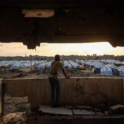 Ein Mann blickt vom Balkon eines Gebäudes auf das Flüchtlingscamp in Nuseirat.