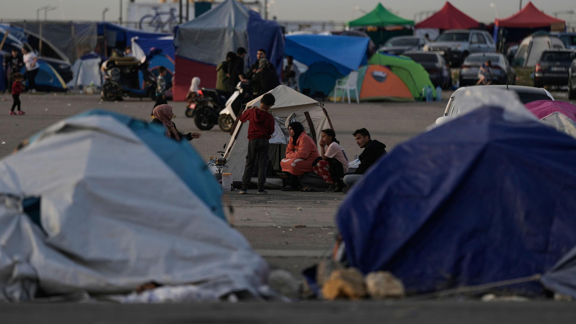 Vertriebene sitzen in den südlichen Vororten Beiruts vor Zelten, die als Unterkunft dienen | Bilal Hussein/AP/dpa