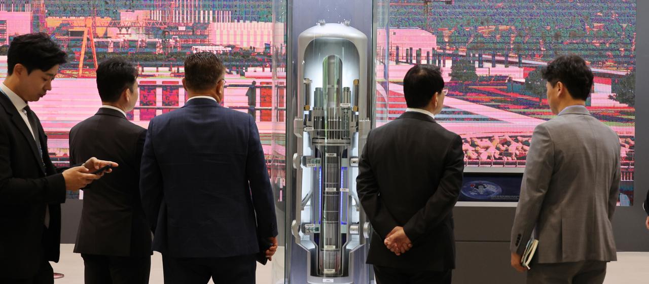 Besucher betrachten ein Modell eines kleinen modularen Reaktors während der Internationalen Kernenergie-Messe im BEXCO-Ausstellungszentrum in Busan, Südkorea.