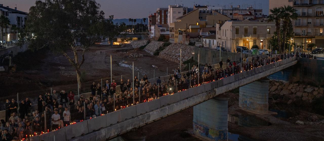 Mit Kerzen in Händen bilden Teilnehmer einer Gedenkveranstaltung eine Menschenkette in Paiporta, Spanien. | dpa Mit Kerzen in Händen bilden Teilnehmer einer Gedenkveranstaltung eine Menschenkette in Paiporta, Spanien.
