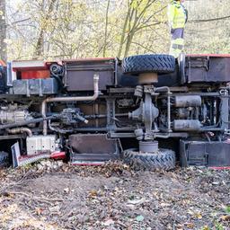 Ein recht neues Spezialfahrzeug der Feuerwehr liegt auf der Seite im Wald. Man sieht nur die vielen Räder un den Unterboden.