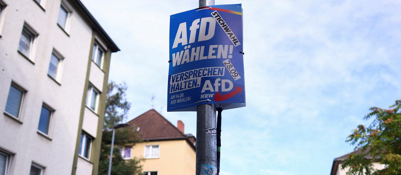 Ein AfD-Mitglied befestigt in Gelsenkirchen ein Wahlplakat der AfD. | REUTERS Ein AfD-Mitglied befestigt in Gelsenkirchen ein Wahlplakat der AfD.