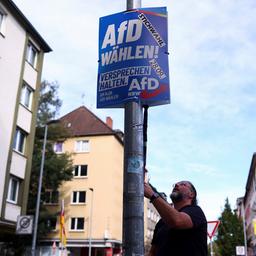 Ein AfD-Mitglied befestigt in Gelsenkirchen ein Wahlplakat der AfD.