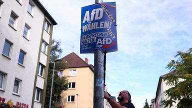 Ein AfD-Mitglied befestigt in Gelsenkirchen ein Wahlplakat der AfD.