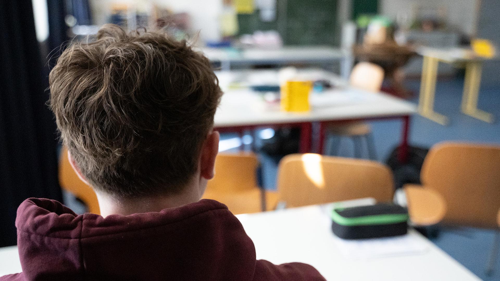 Ein Schüler sitzt an einem Tisch im Klassenzimmer einer Schule. | dpa