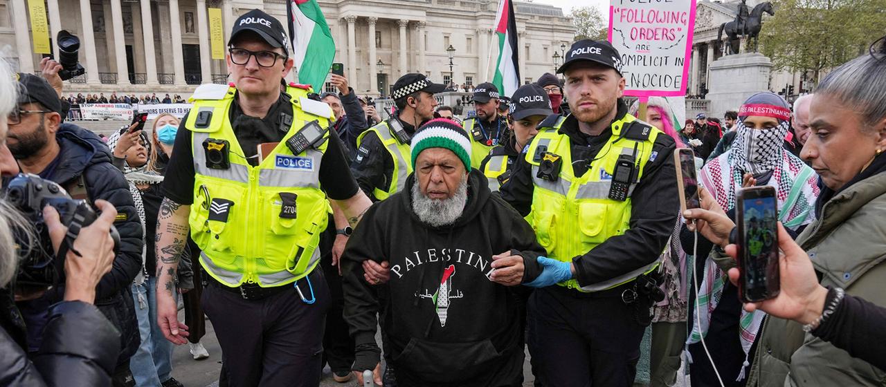 Britische Polizisten führen einen Demonstranten ab.